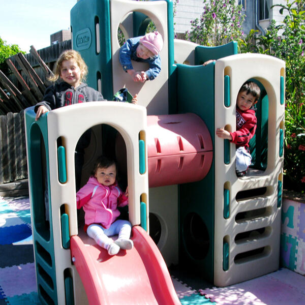 Untitled Children climbing and playing on the backyard structure