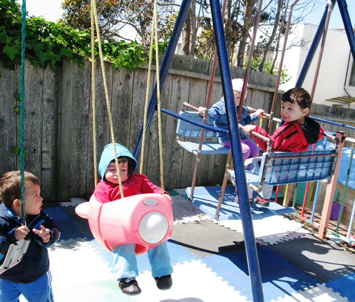 Untitled Children enjoying swings in the backyard playground