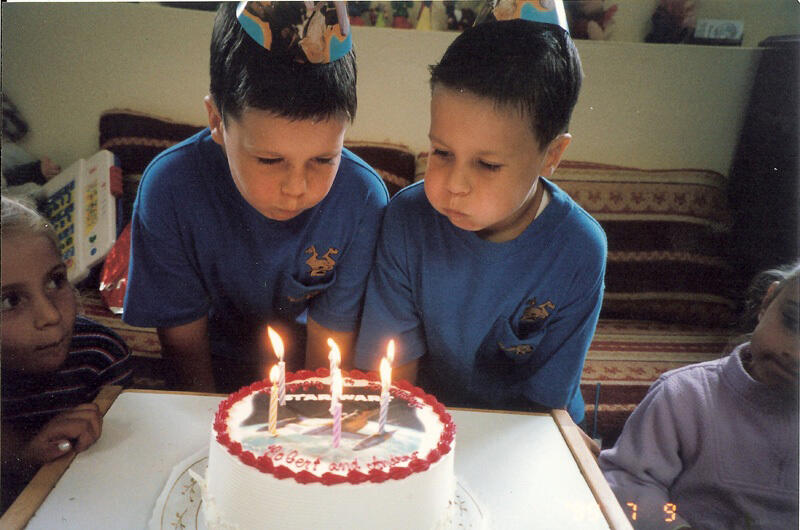 Untitled Child celebrating a birthday with cake and friends