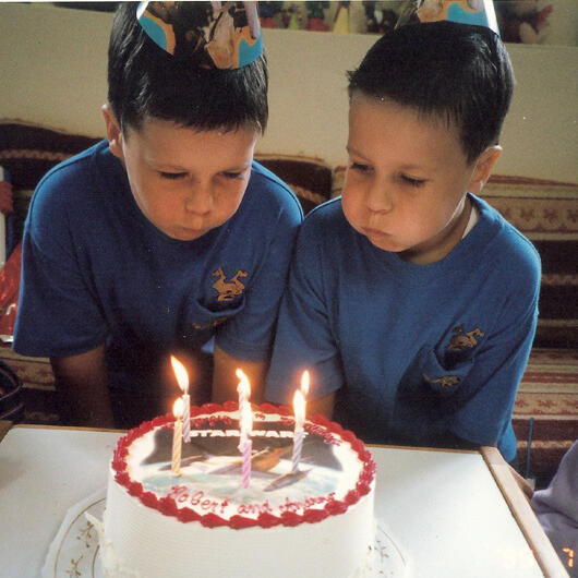 Untitled Twin brothers blowing out birthday candles