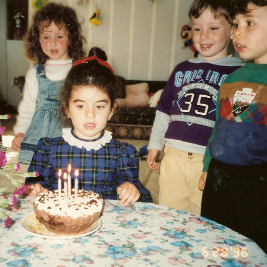 Untitled Child celebrating a birthday with cake and friends