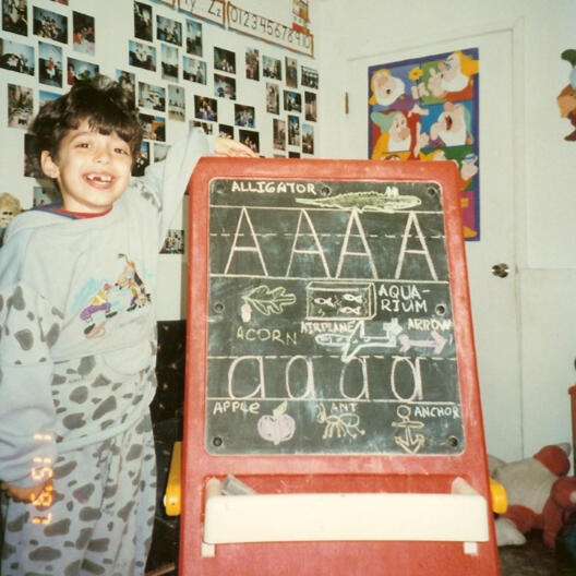 Untitled Child learning letters on a chalkboard