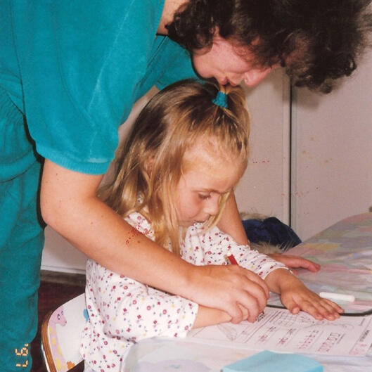 Untitled Lana helping a child with writing practice at her San Francisco preschool.