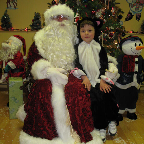 Untitled Child in costume with Santa during a holiday celebration